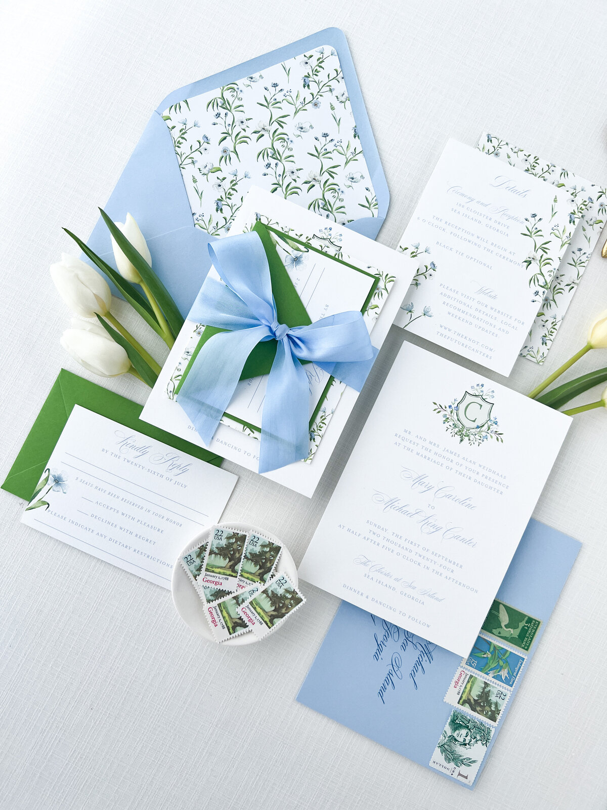 a flat lay of a garden themed wedding invitation suite