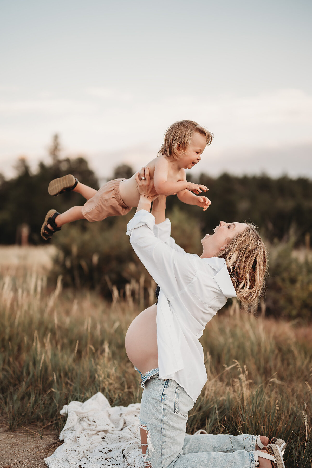 mom lifting her son over her head with her pregnant belly showing sideways