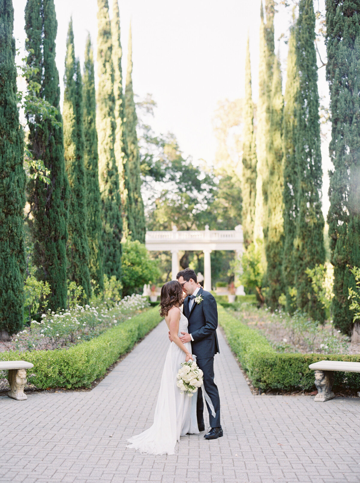bride and groom kissing in the middle of symmetrical landscaping at montalvo arts center garden