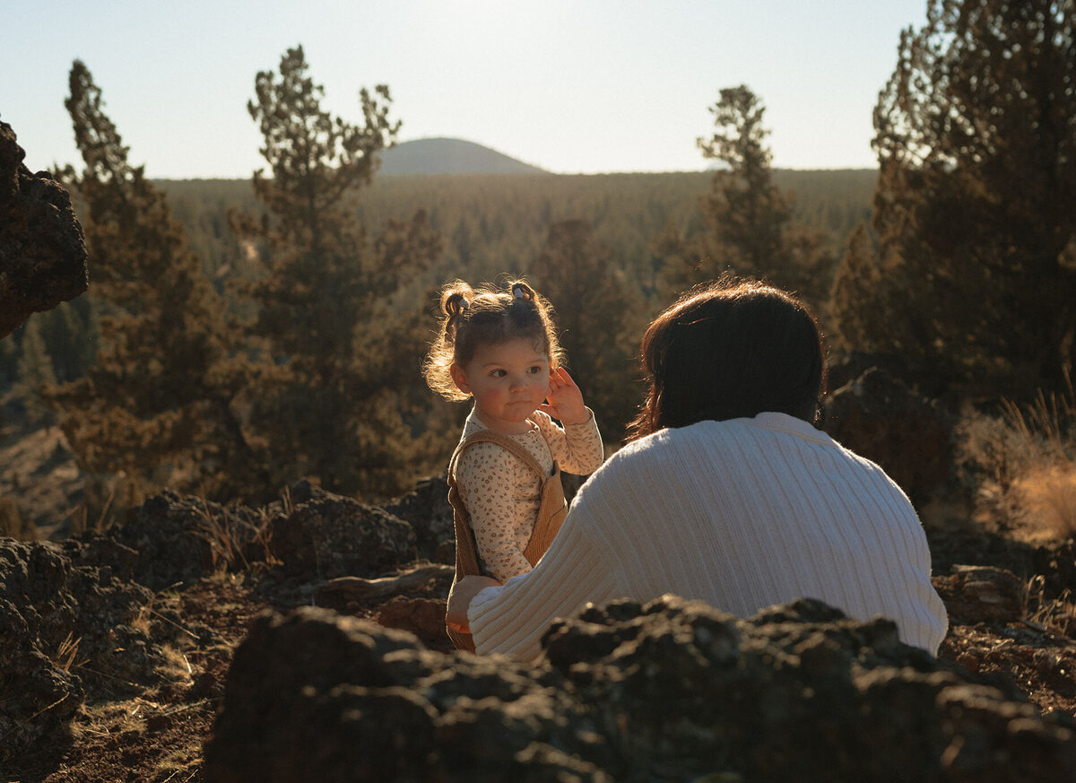 mother and toddler exchange looks while enjoying the scenery during sunset in Bend, Oregon