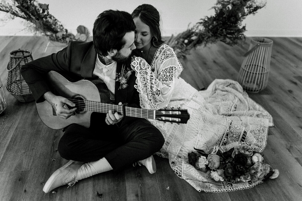 black and white photo of couple playing guitar
