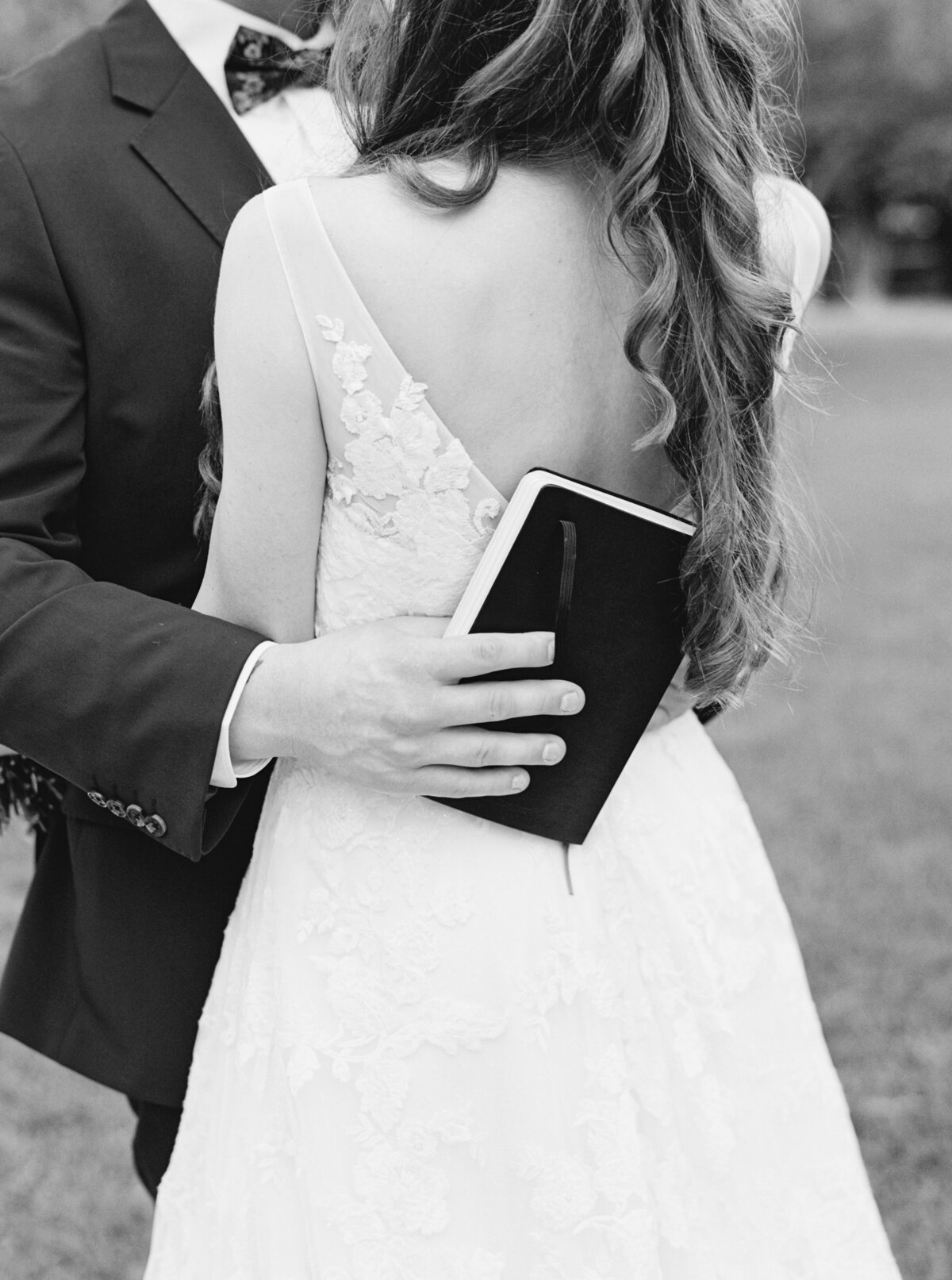 A classic black-and-white portrait capturing an intimate embrace between bride and groom, showcasing elegance and emotion on film by Morgan Alysse, Louisiana film photographer.