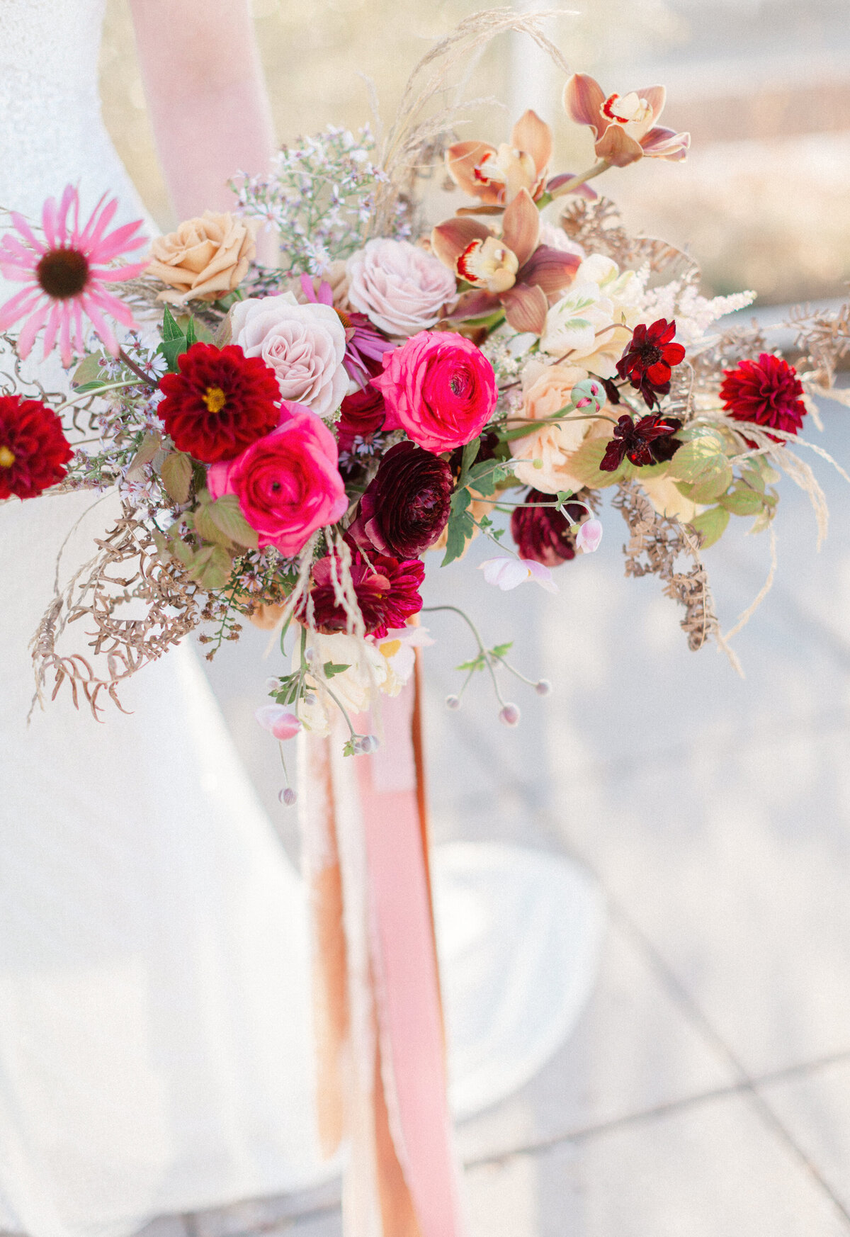 A bright bouquet of pink and red flowers tied by a pink ribbon at Le Livart.