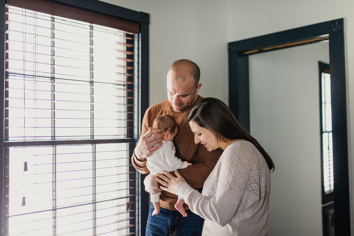 Infant photography of a mom and dad holding baby