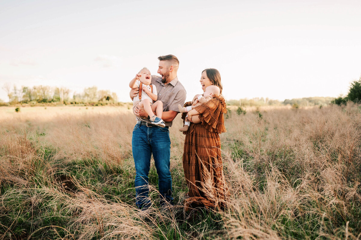 Branson family photo of family tickling kids in a field