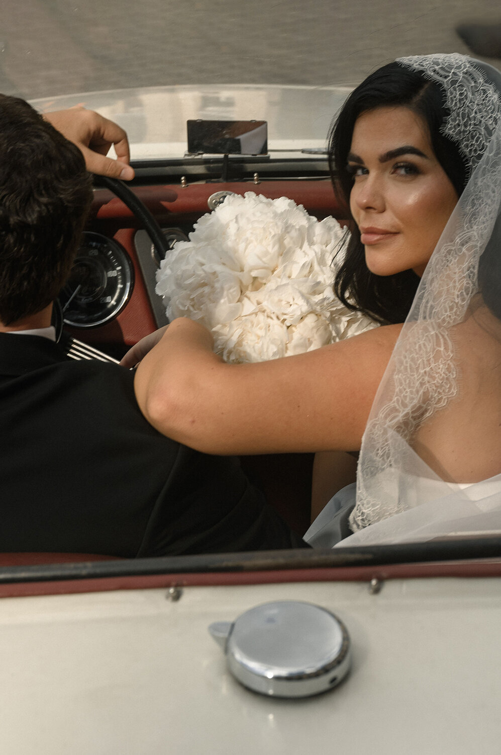 Modern bride with white peonies bouquet in Paris