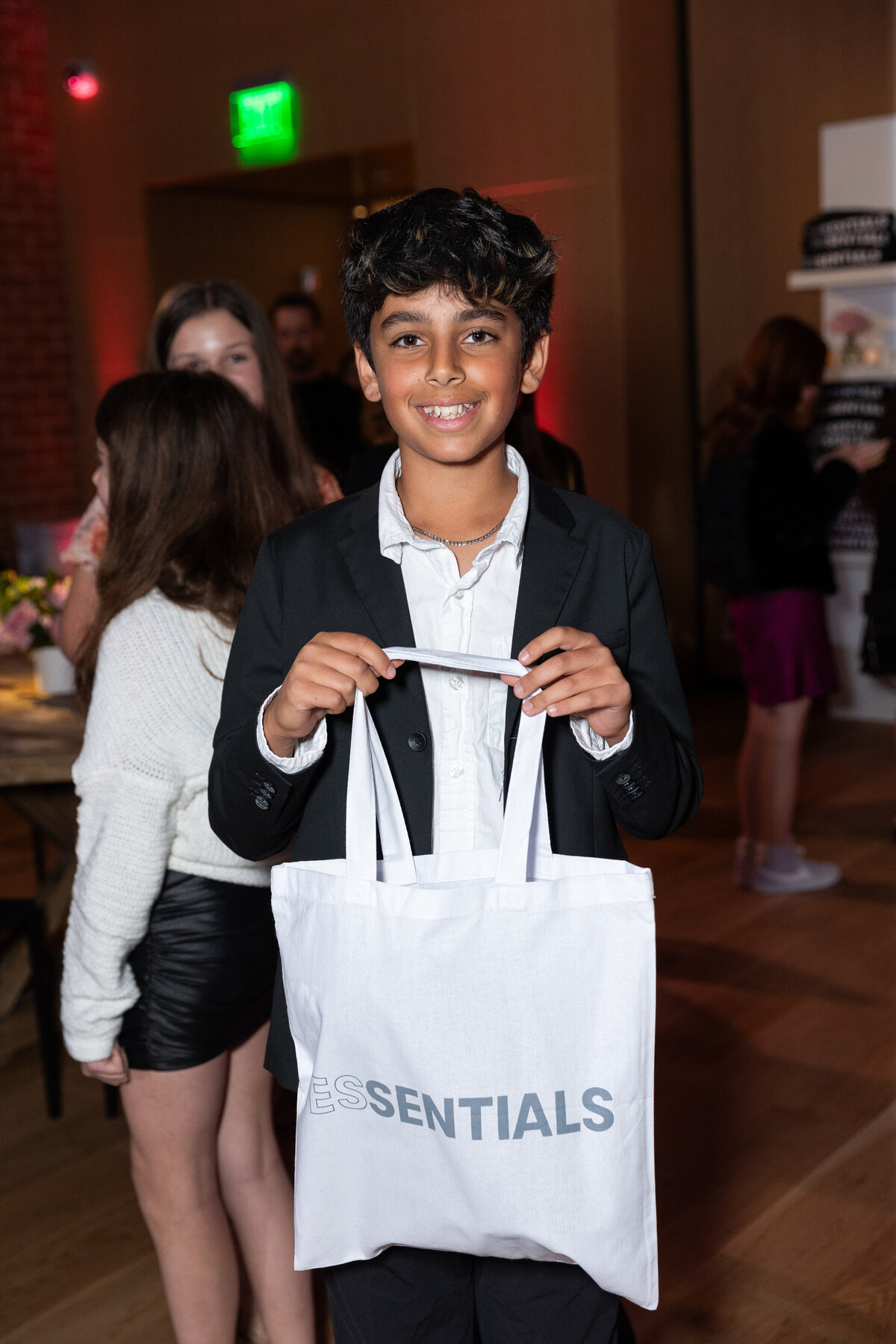 A boy holding up a tote bag