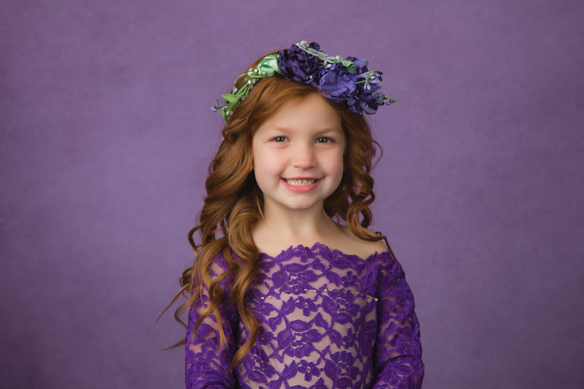 girl-in-studio-with-purple-lace-dress-and-long-red hair-on-purple-backdrop-arlington-tx