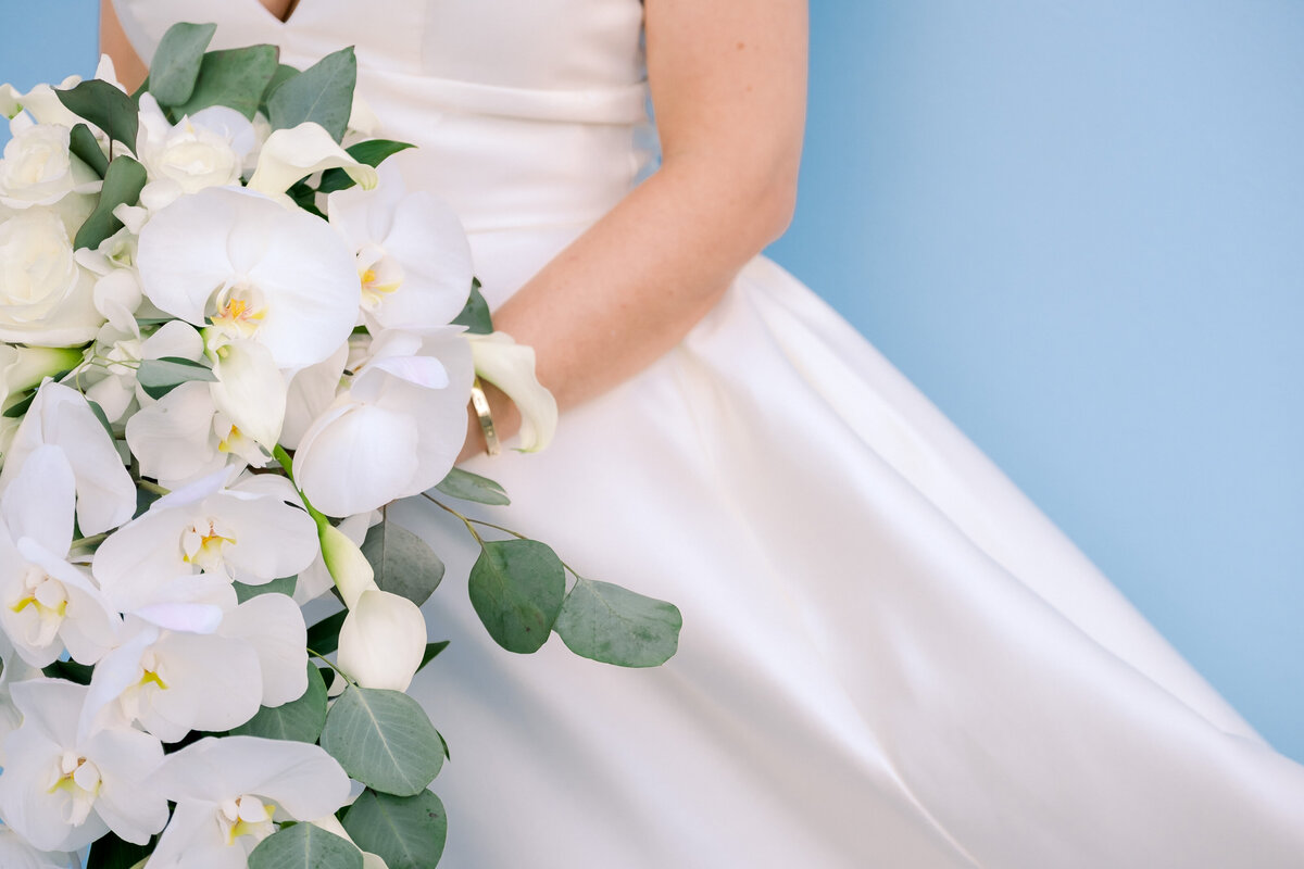 A symetrical photo of the bride holding an orchid filled bouquet in Miami