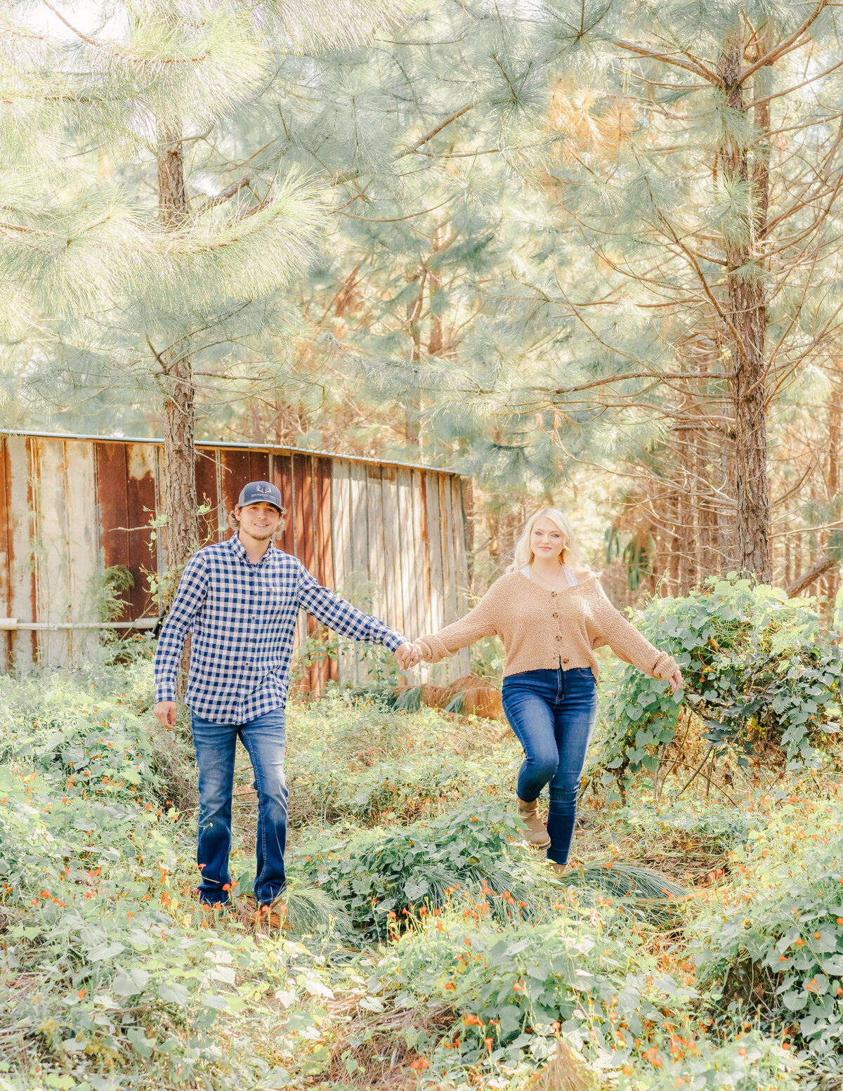 Husband and wife walking from barn holding hands and laughing
