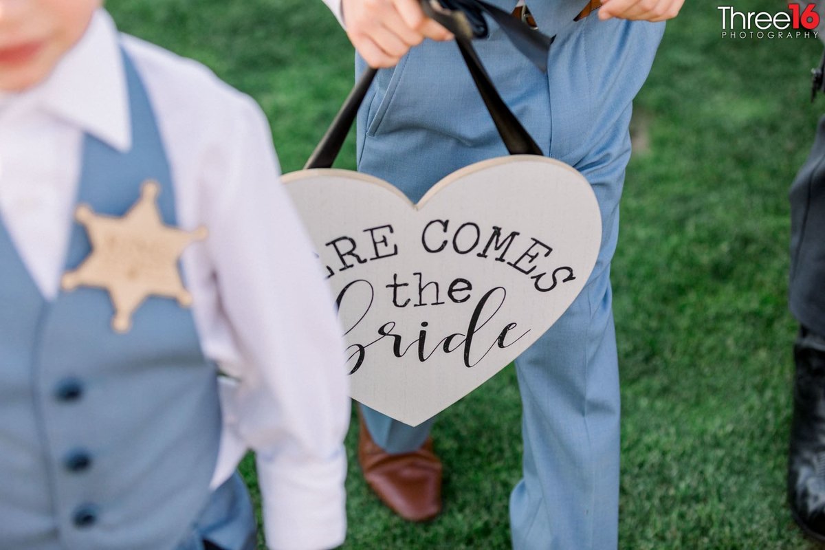 Ring Bearer's sign announces to the crowd that the Bride is on her way