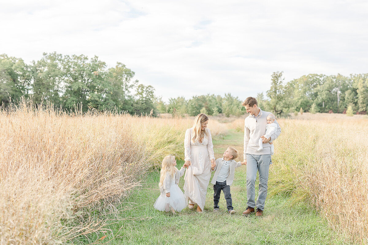 parents and kids walking in the field during Arlington, VA family photoshoot