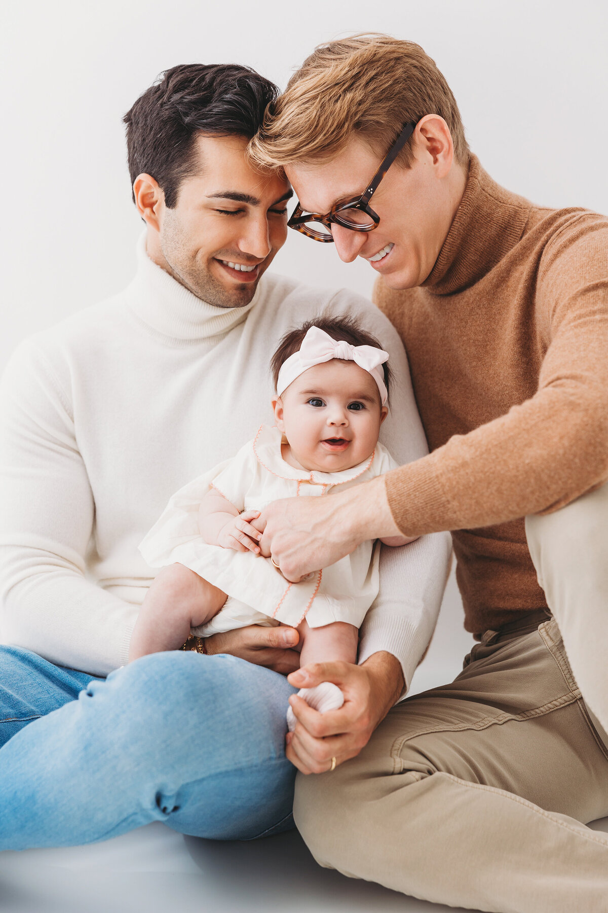 Gay men holding their daughter in Phoenix family session at Phoenix photography studio