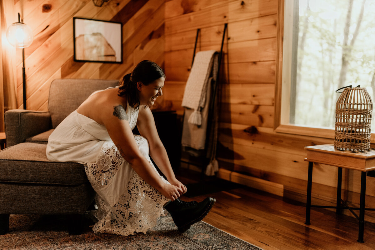 Bride laces up her Doc Martens before hiking to elopement