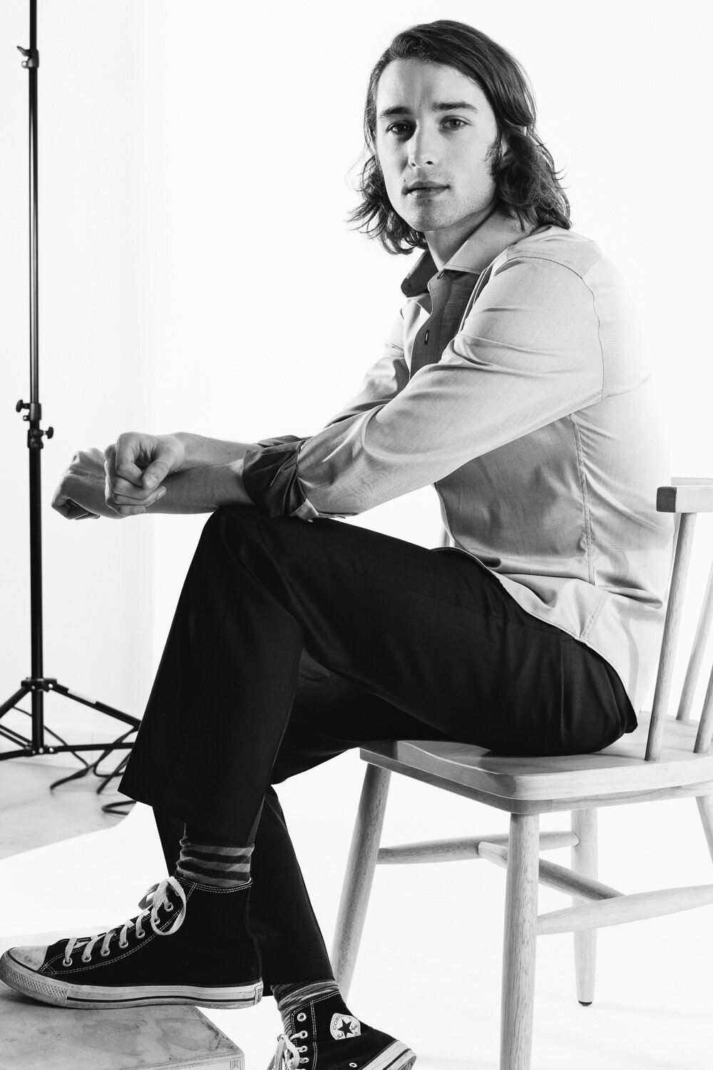 Editorial fashion-style headshot of a man captured in a studio setting.