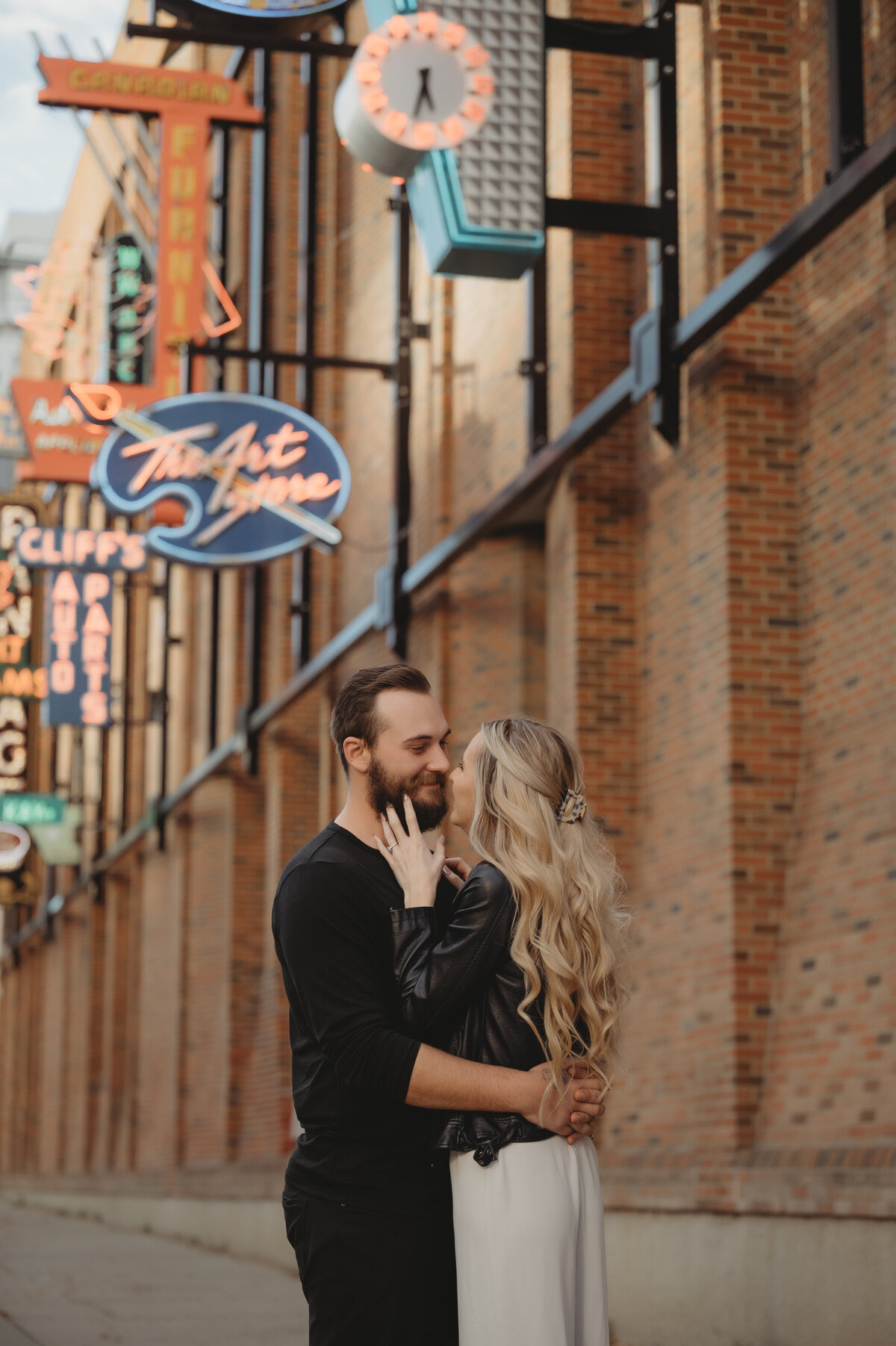 Engaged Alberta Couple in front on Neon Sign Museum in Edmonton