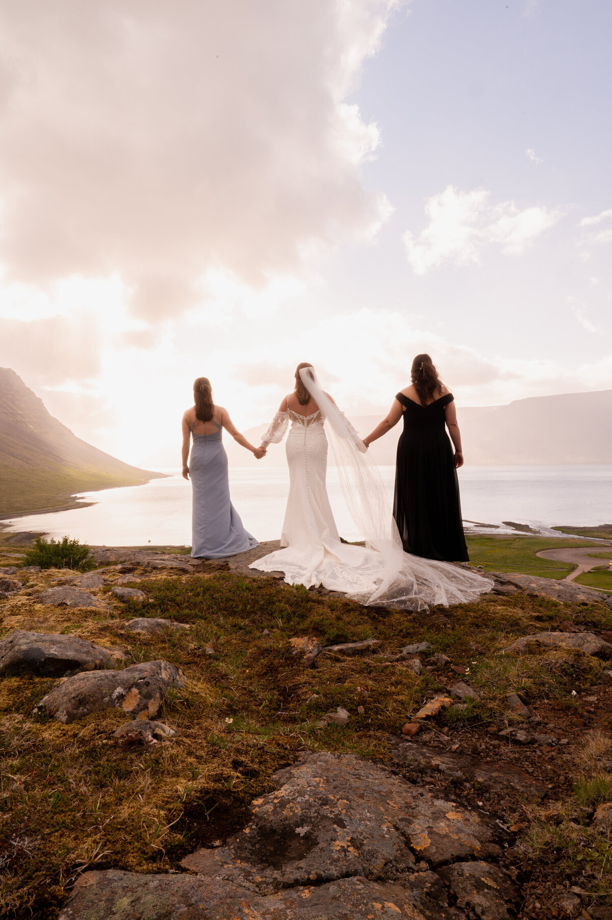 Wedding portraits of a bride and her bridesmaids overlooking the Northern coast of Iceland at Dynjandi Waterfall.
