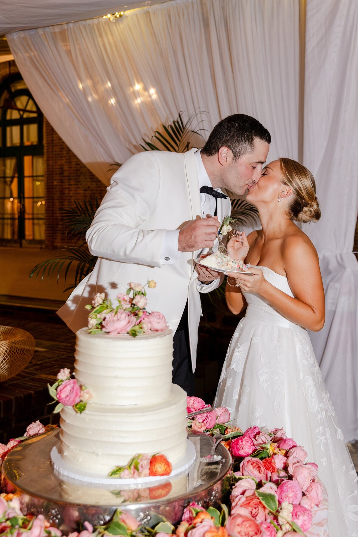 bride and groom kissing during cake cutting