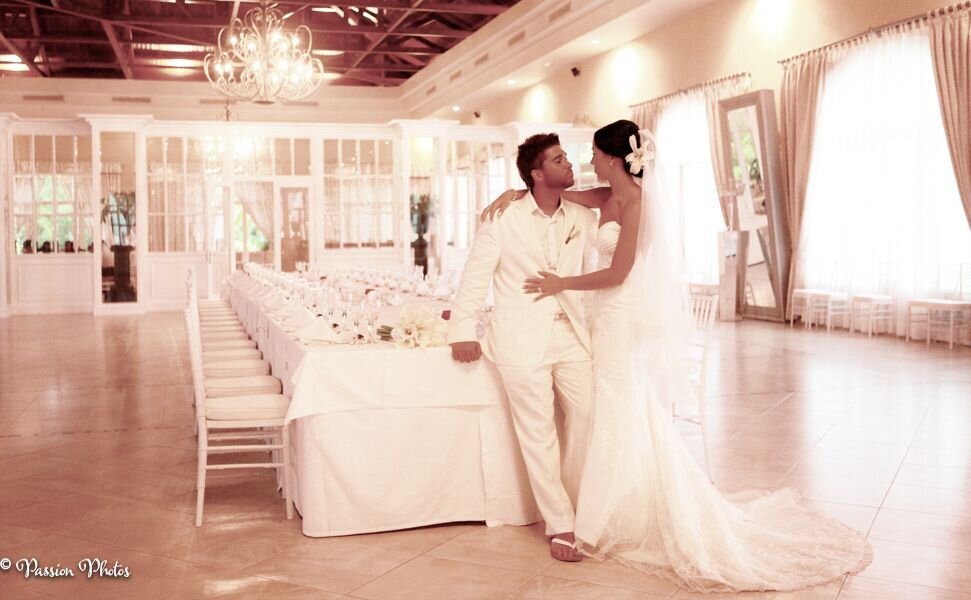 A couple shares a romantic kiss in a beautifully designed, empty dining area set in an exotic location. This image highlights the elegance and intimacy of destination weddings, capturing a serene and exclusive moment amidst the stunning surroundings.