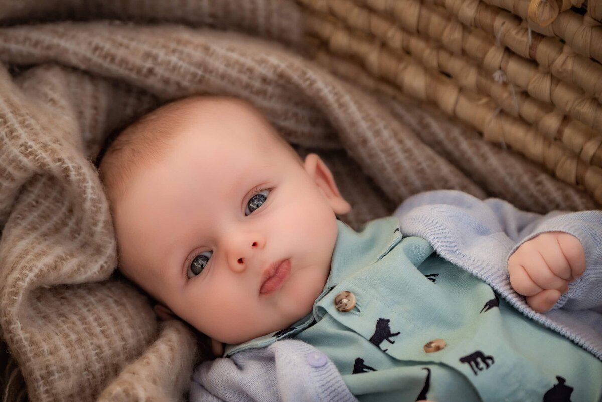 baby boy with blue eyes in moses basket
