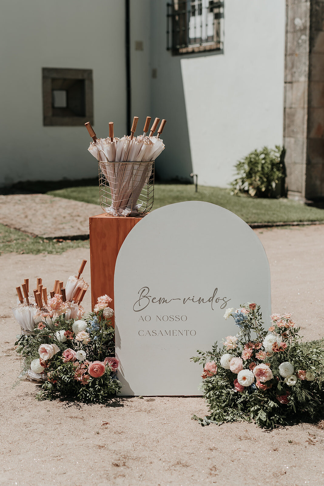 Beautiful arched wedding sign and white parasols outside a Portuguese wedding venue in Ponte de Lima