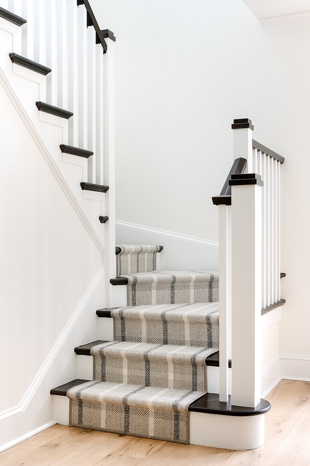 neutral colored stairs with striped stair runners