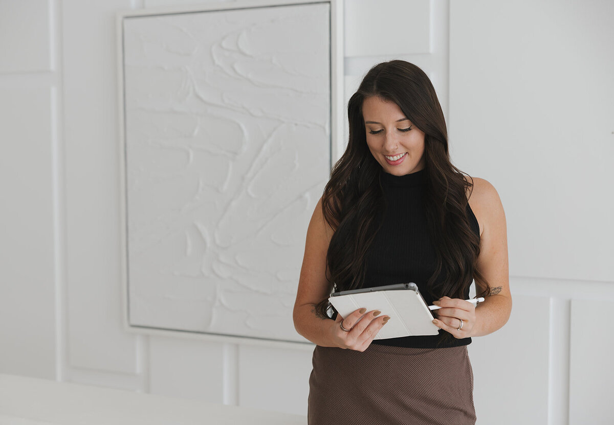 Danielle looking down at ipad while writing on it