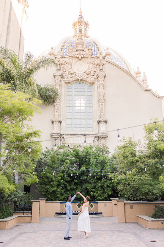couple-twirling-by-Museum-of-Us-balboa-park-san-diego