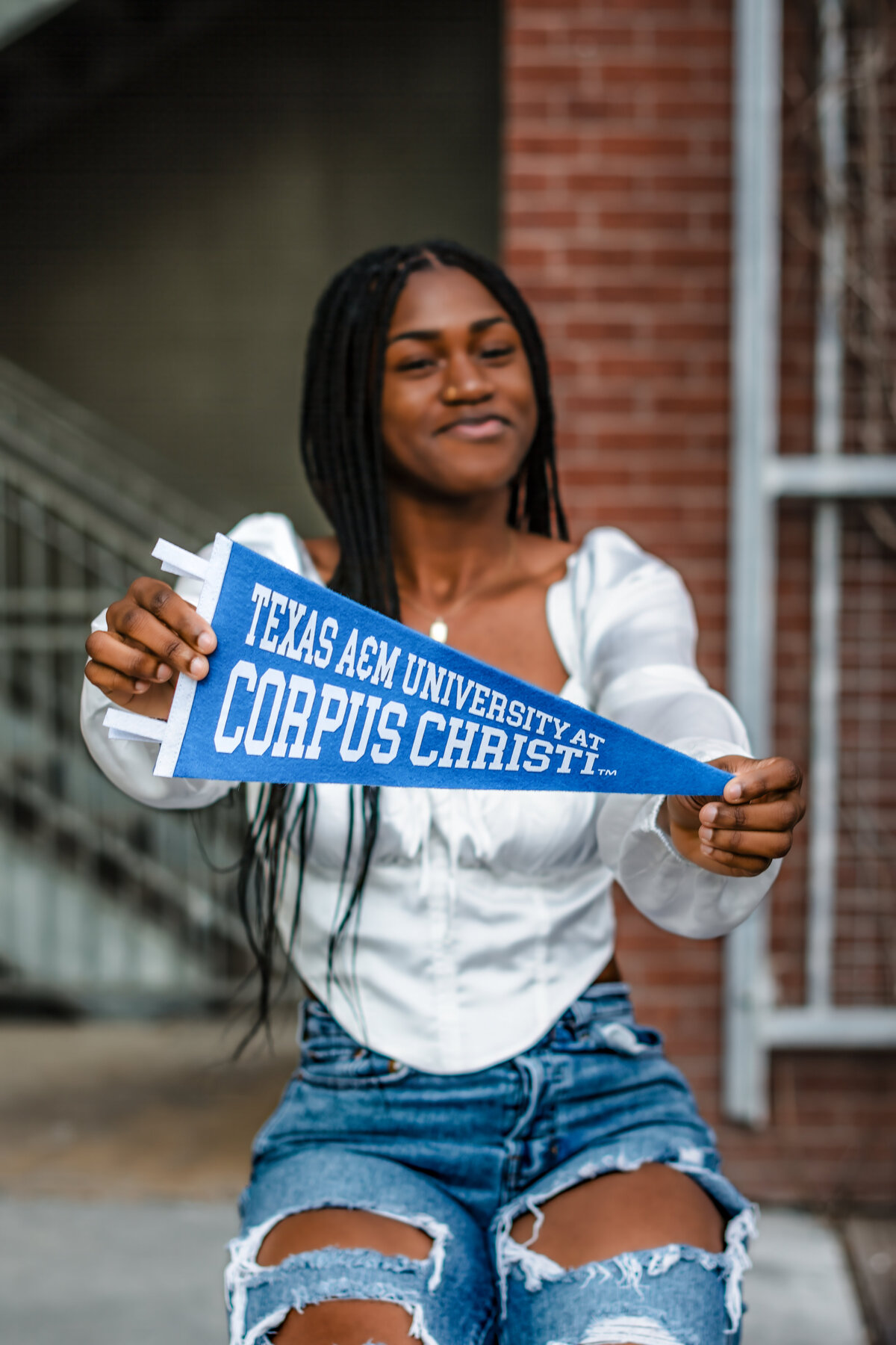 Close-up of Steel High School senior holding college pennant with proud smile at The Pearl.