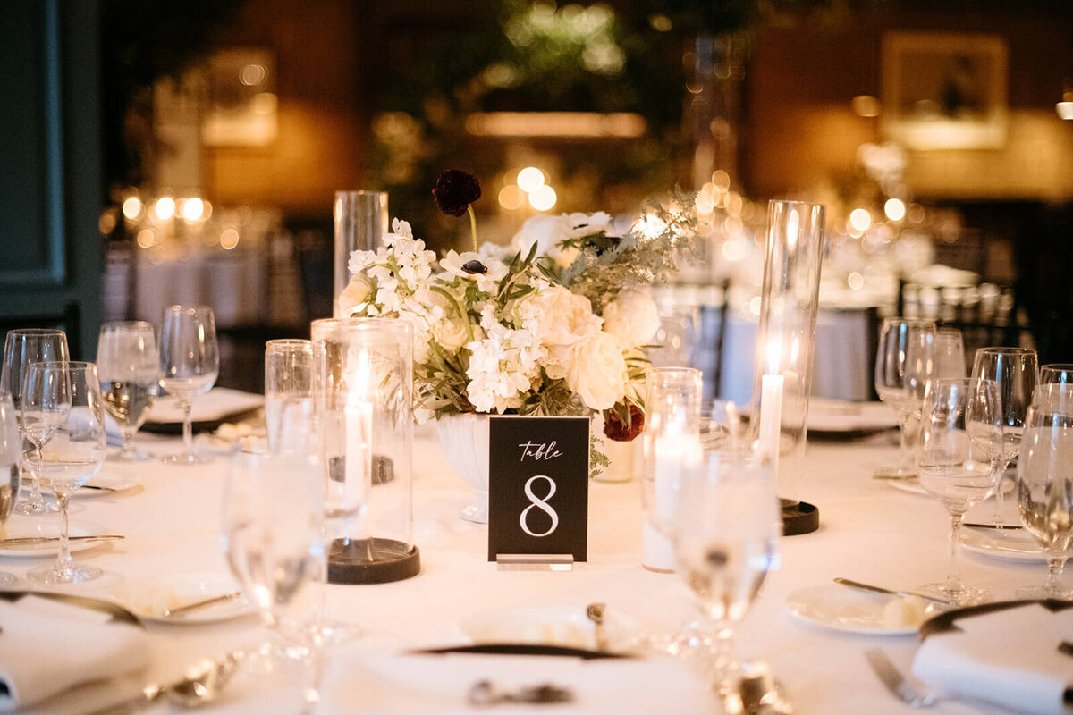 Wedding reception table at St. Regis Aspen with detailed place settings, soft candlelight, and a centerpiece of seasonal flowers.