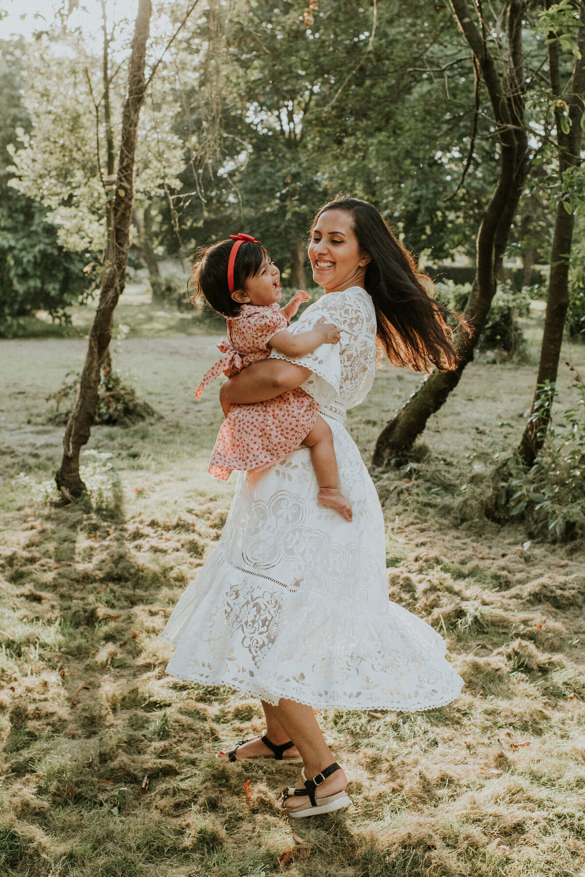 Mother spinning daughter around in nature