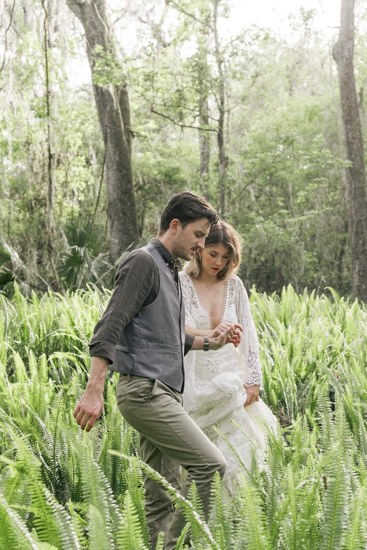 52-groom-leads-bride-ferns