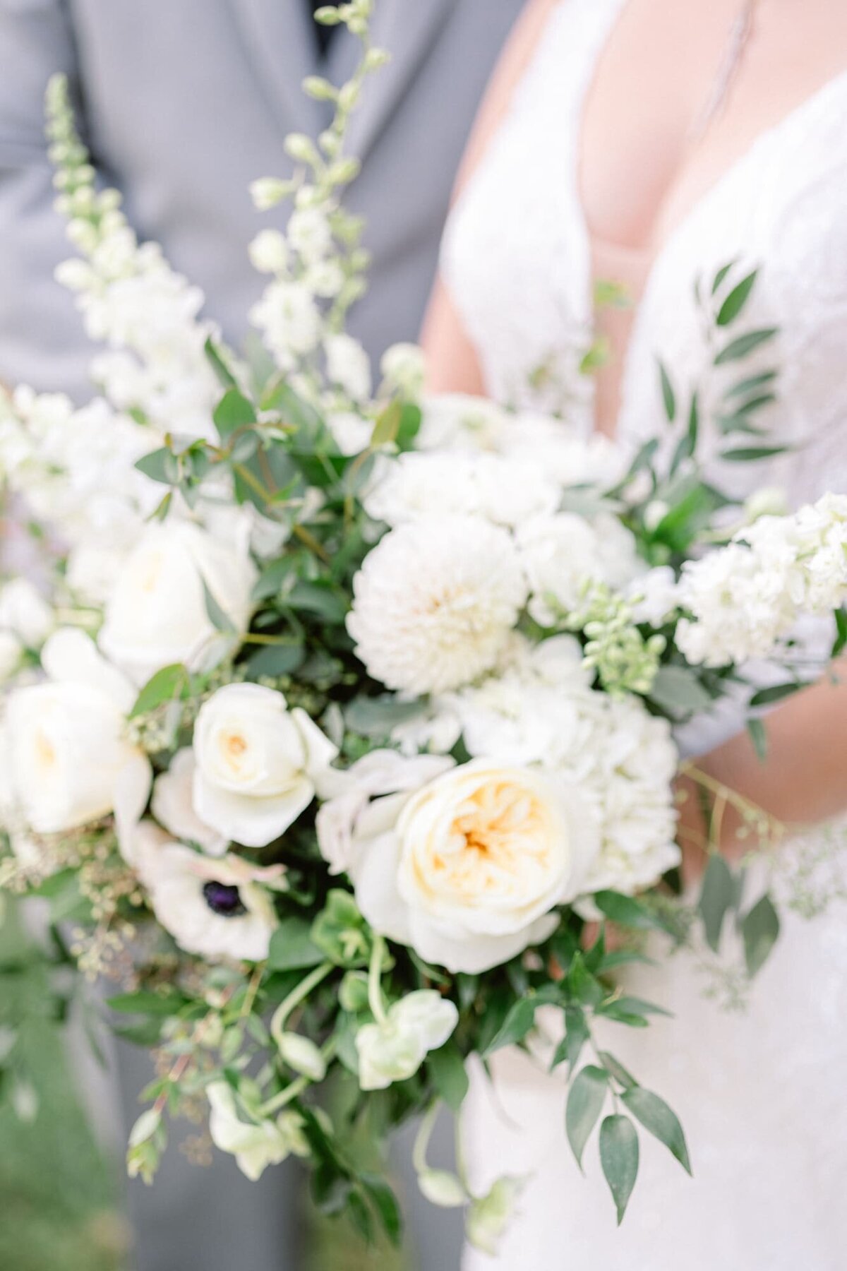 White florals held by bride and groom at Common House wedding
