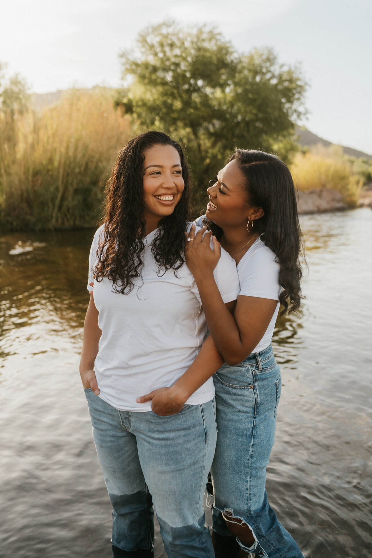 A person standing behind their partner and leaning over to smile at them 