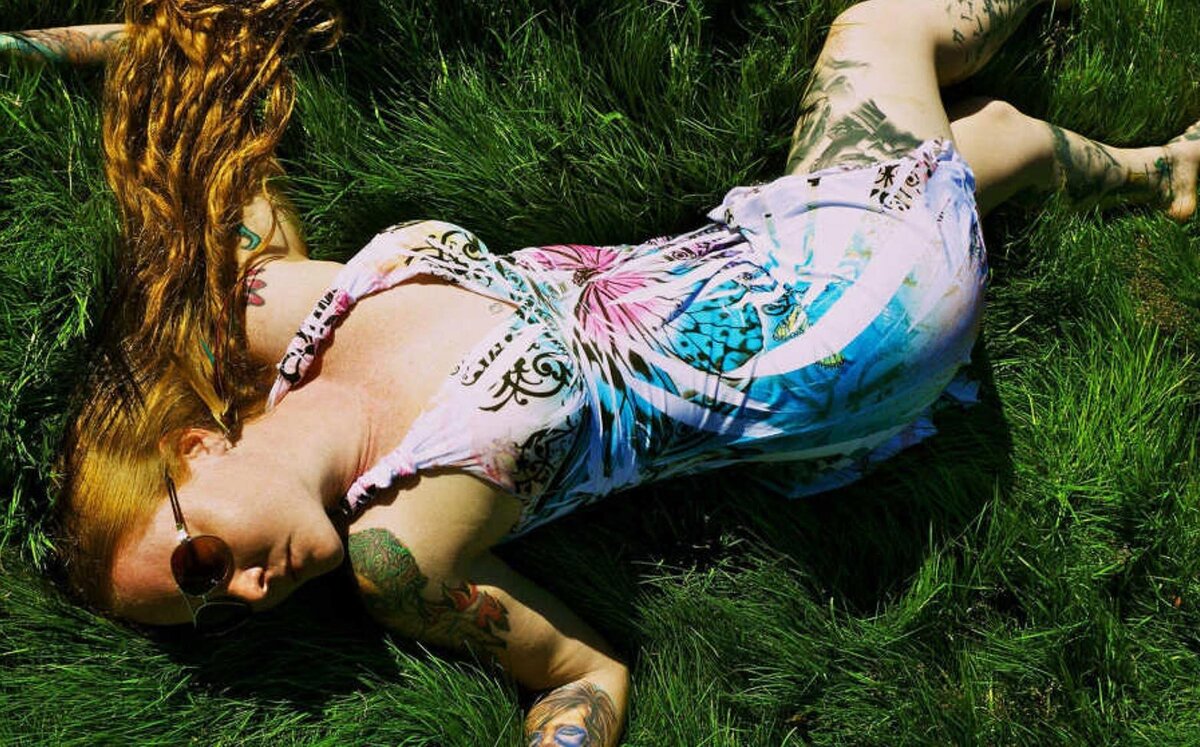 Musician portrait Layla Zoe lying in grass field