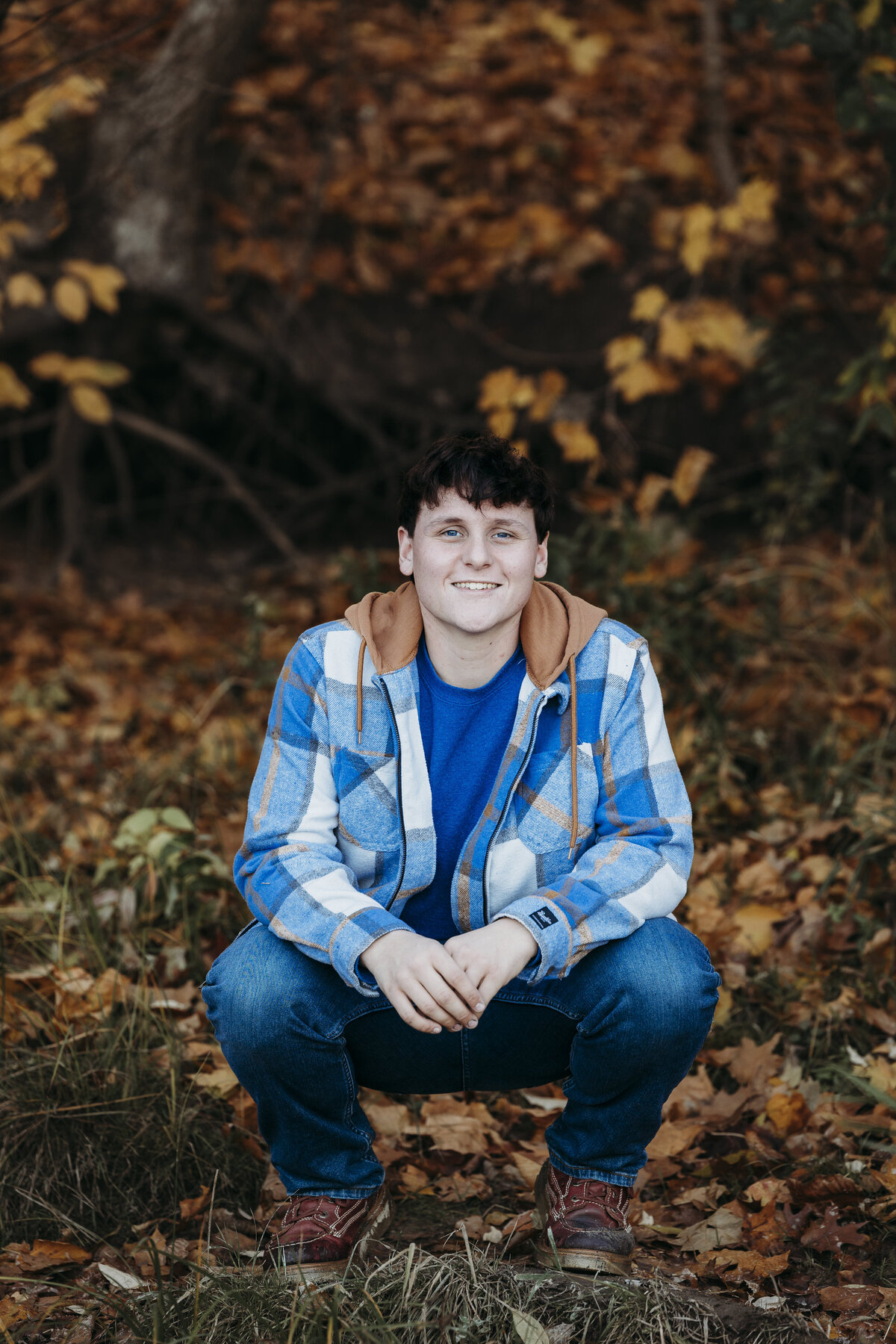 portland-senior-squatting-in-fall-leaves