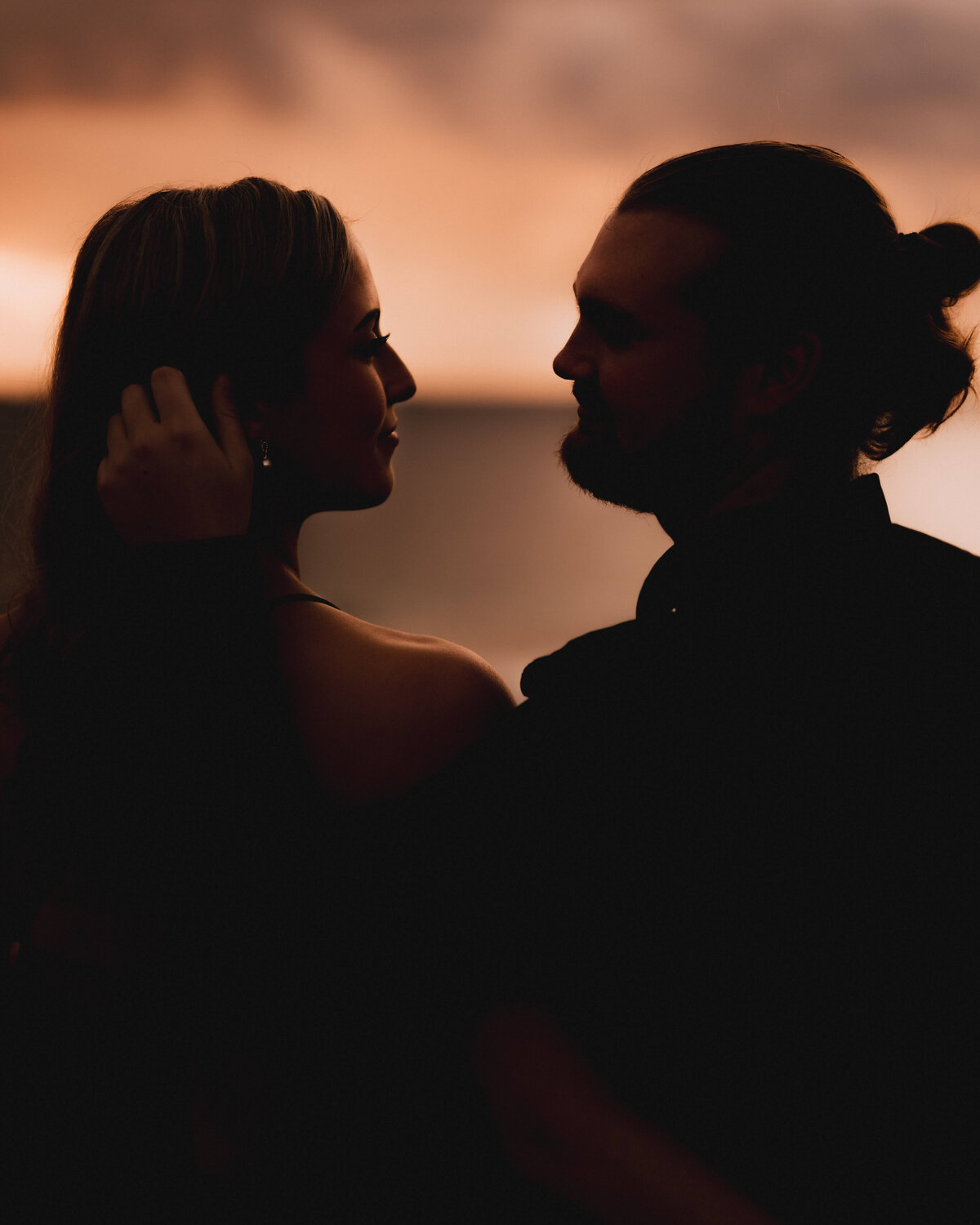 Couple standing in front of sunset