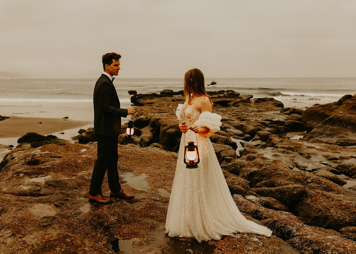 Married couple holding a light lantern beside the seashore