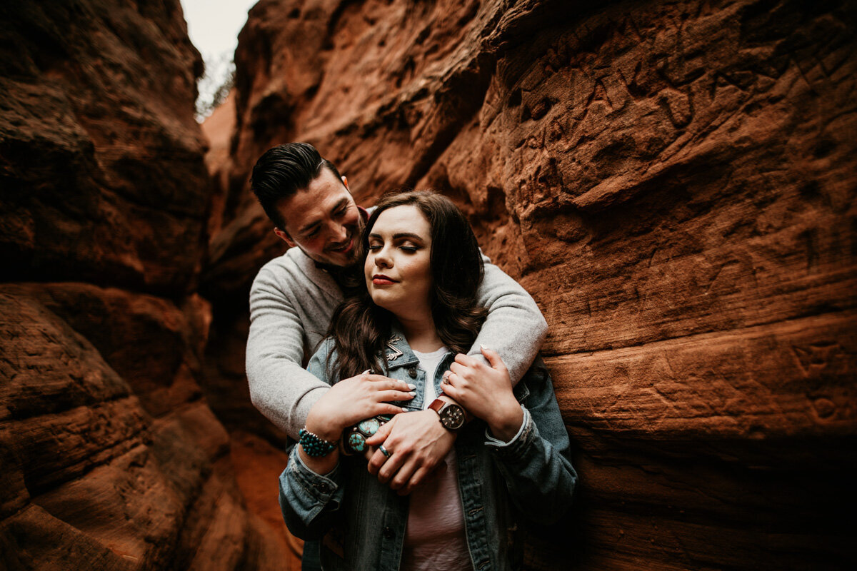 man holding fiancé in canyon
