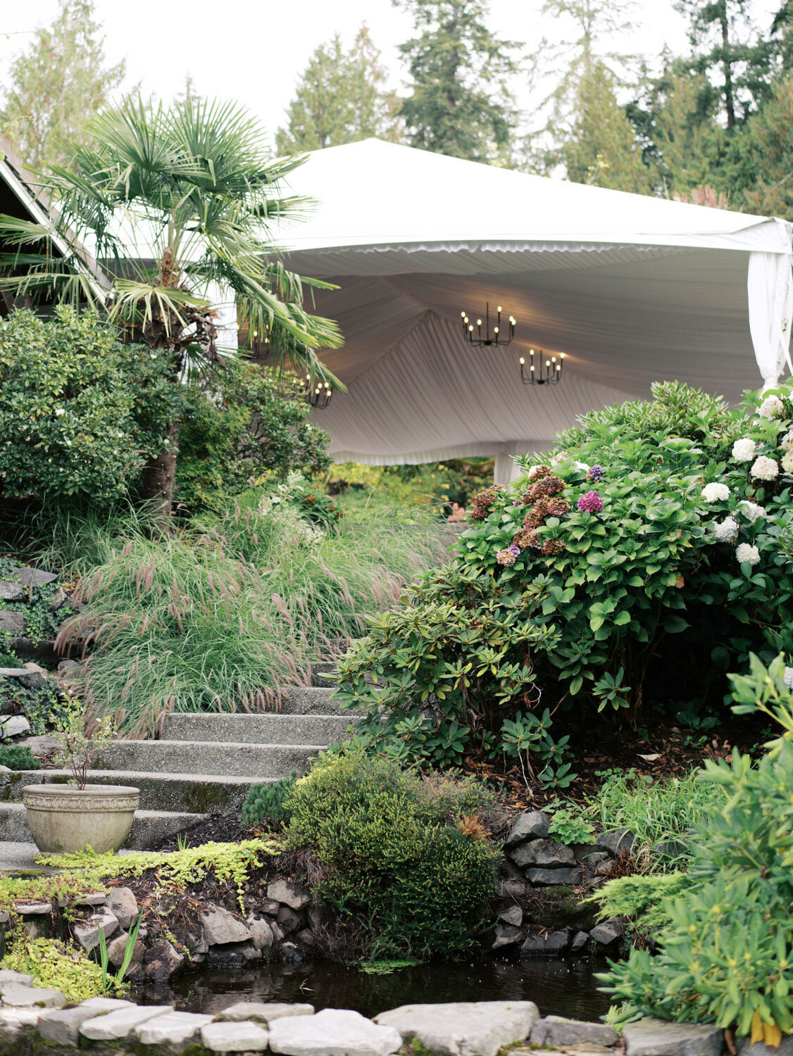 Steps leading to a wedding tent surrounded by lush greenery