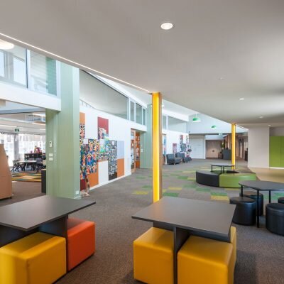Interior of St Paul’s Anglican School showing a brightly lit student lounge with colorful seating and hallway access.