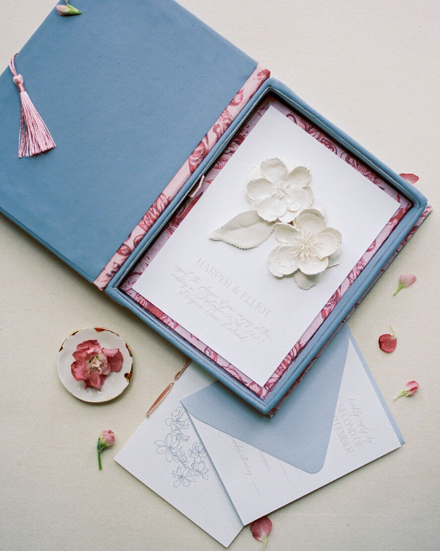 Dominique Alba Studio luxury boxed wedding invitations dusty blue and tassels