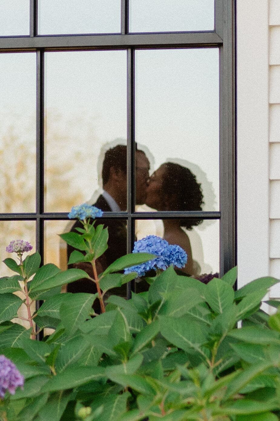 reflection of couple kissing through the window at trinity view farm in franklin tennessee