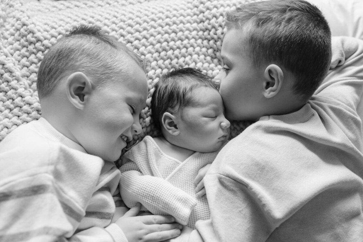 boys snuggled together with baby brother