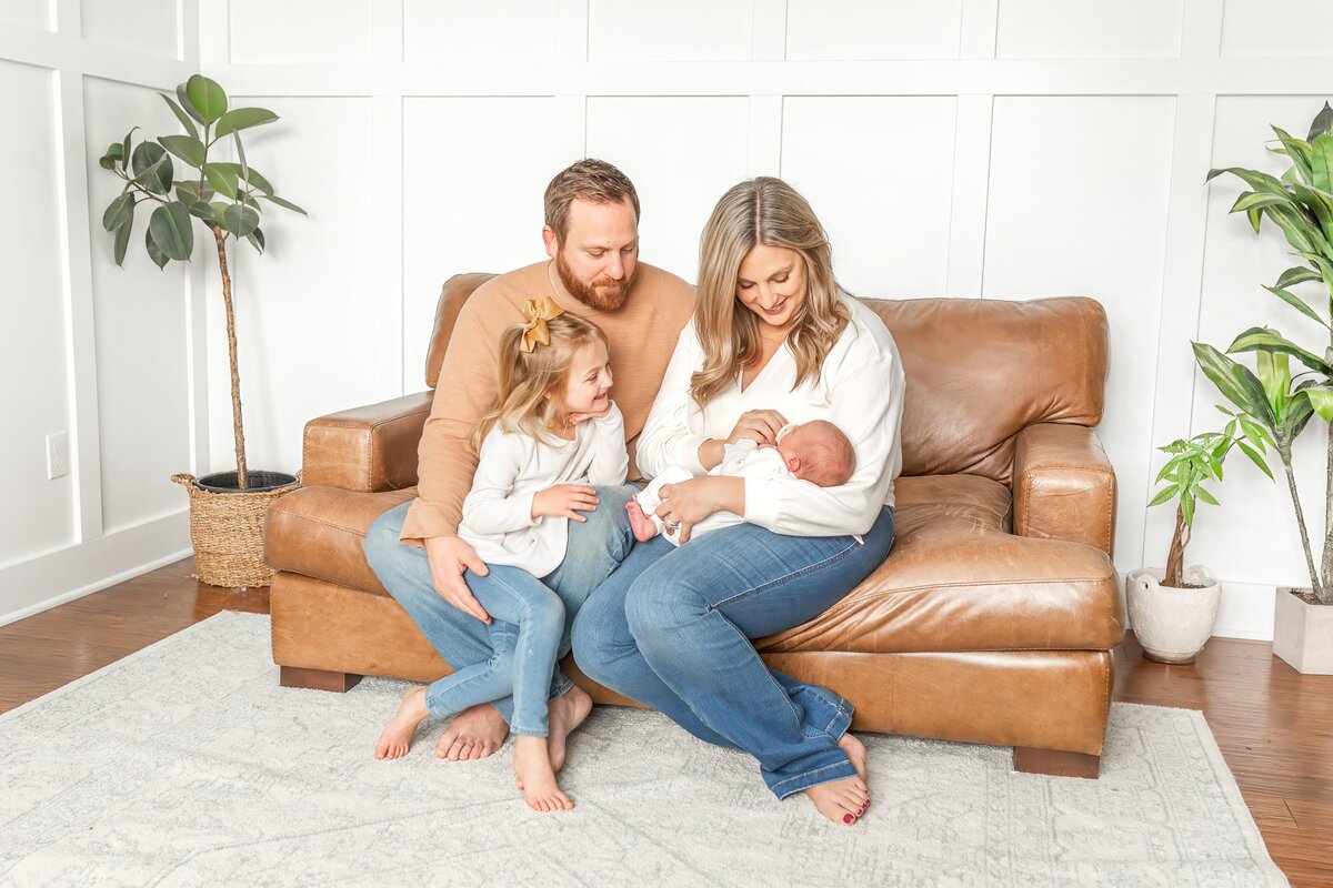 Brooke Leigh Photography takes photo of family during their in home newborn session in Wixom Michigan, holding baby boy