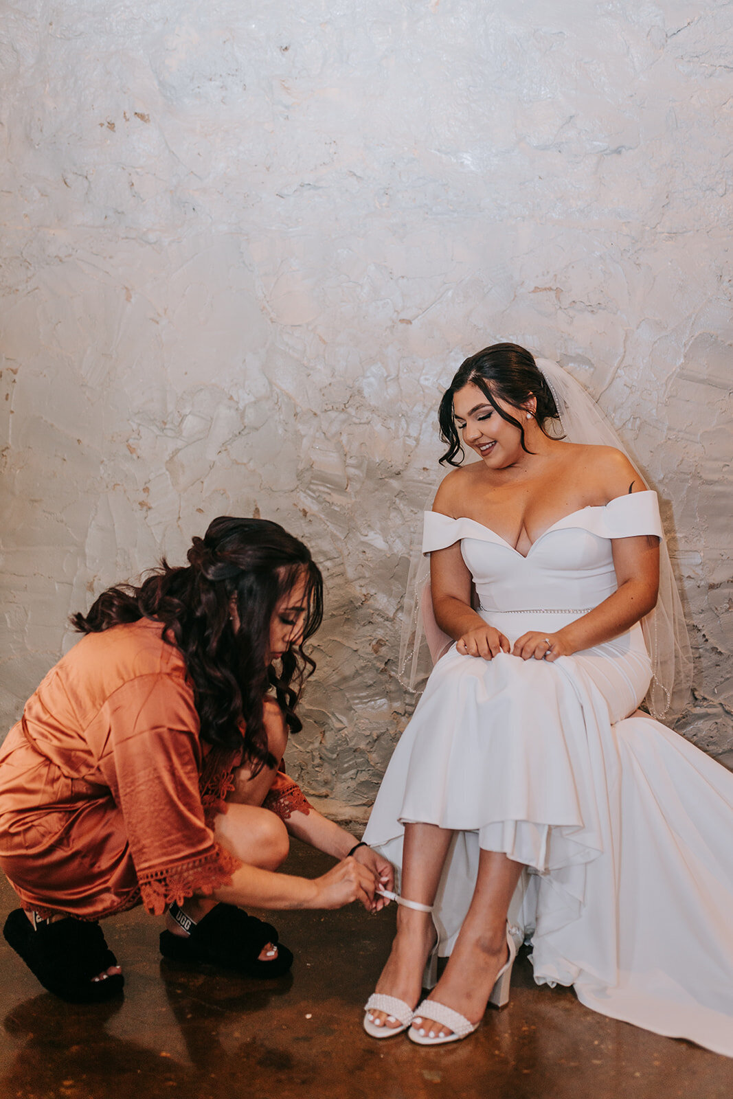 Maid of honor helping bride fix her shoes