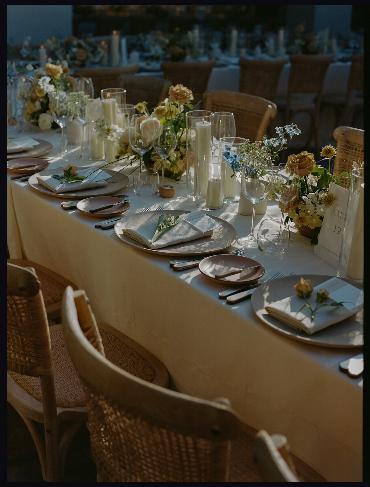 warm earthy tones are shown on this wedding dining table setup .  the design includes casa de perrin china, glassware, and flatware. Theoni dining chairs and linens are also used.