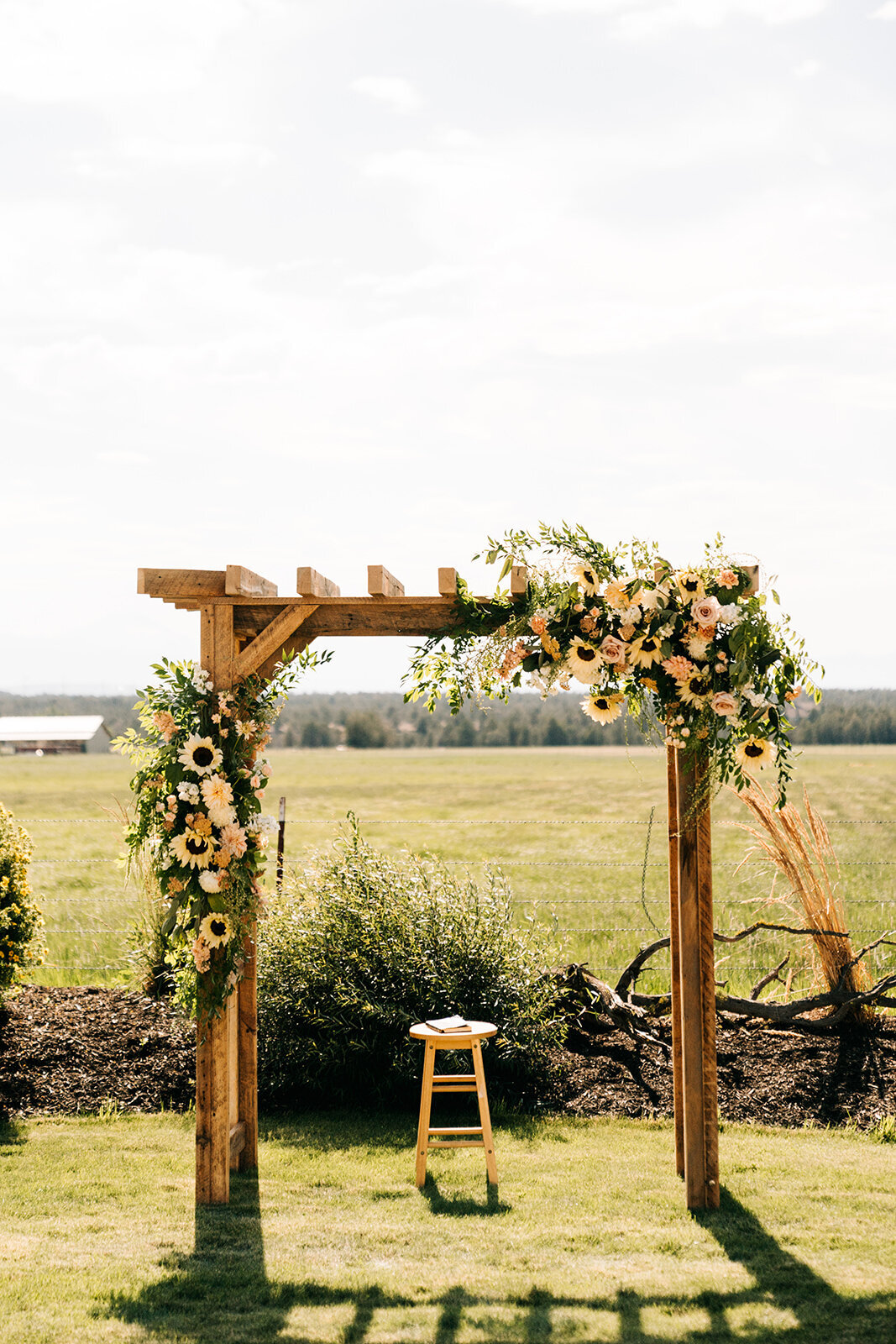Pale sunflowers and pastel flowers on wooden arbor at private ranch in Powell Butte Oregon