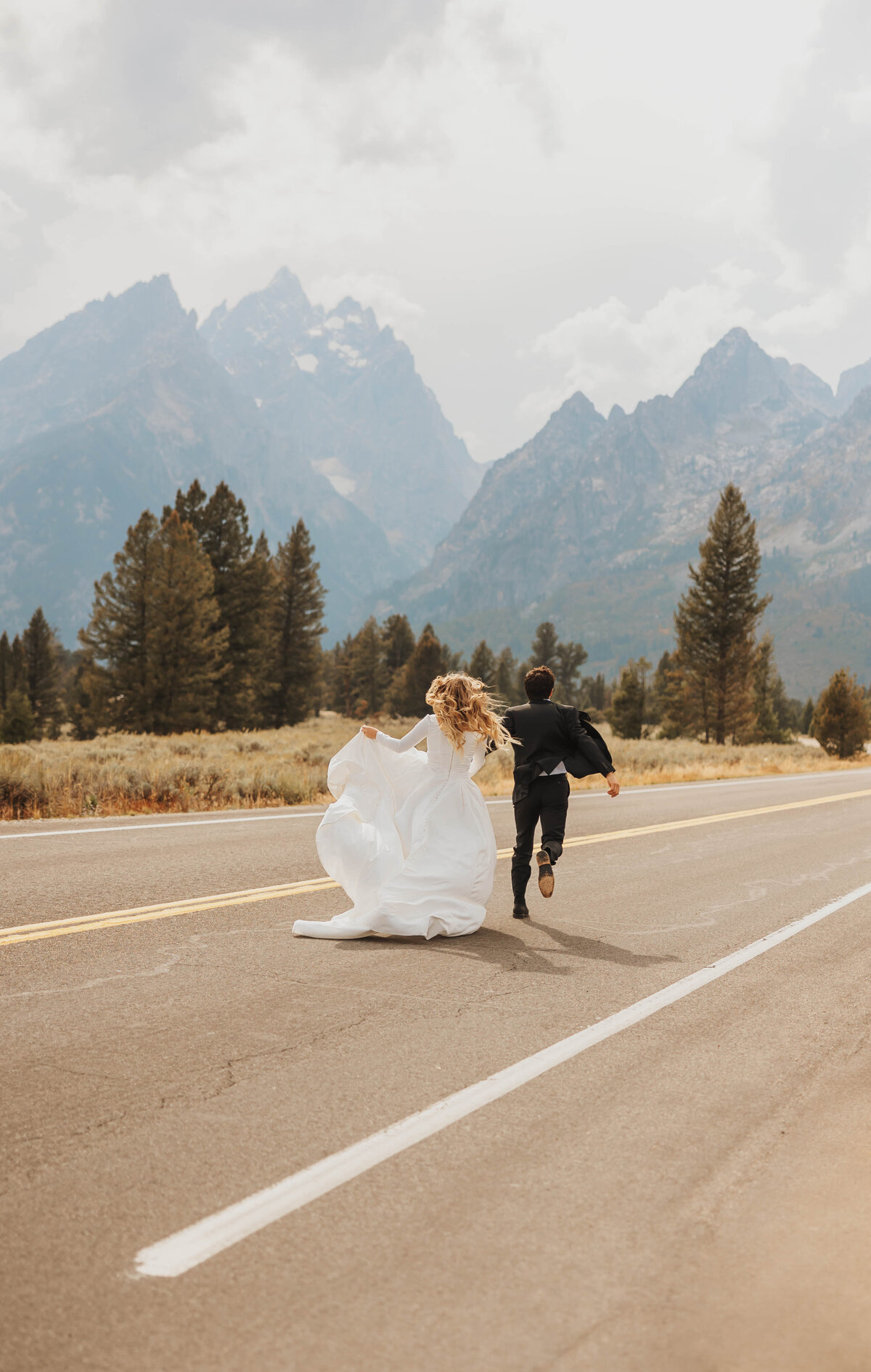 bride and groom running in road