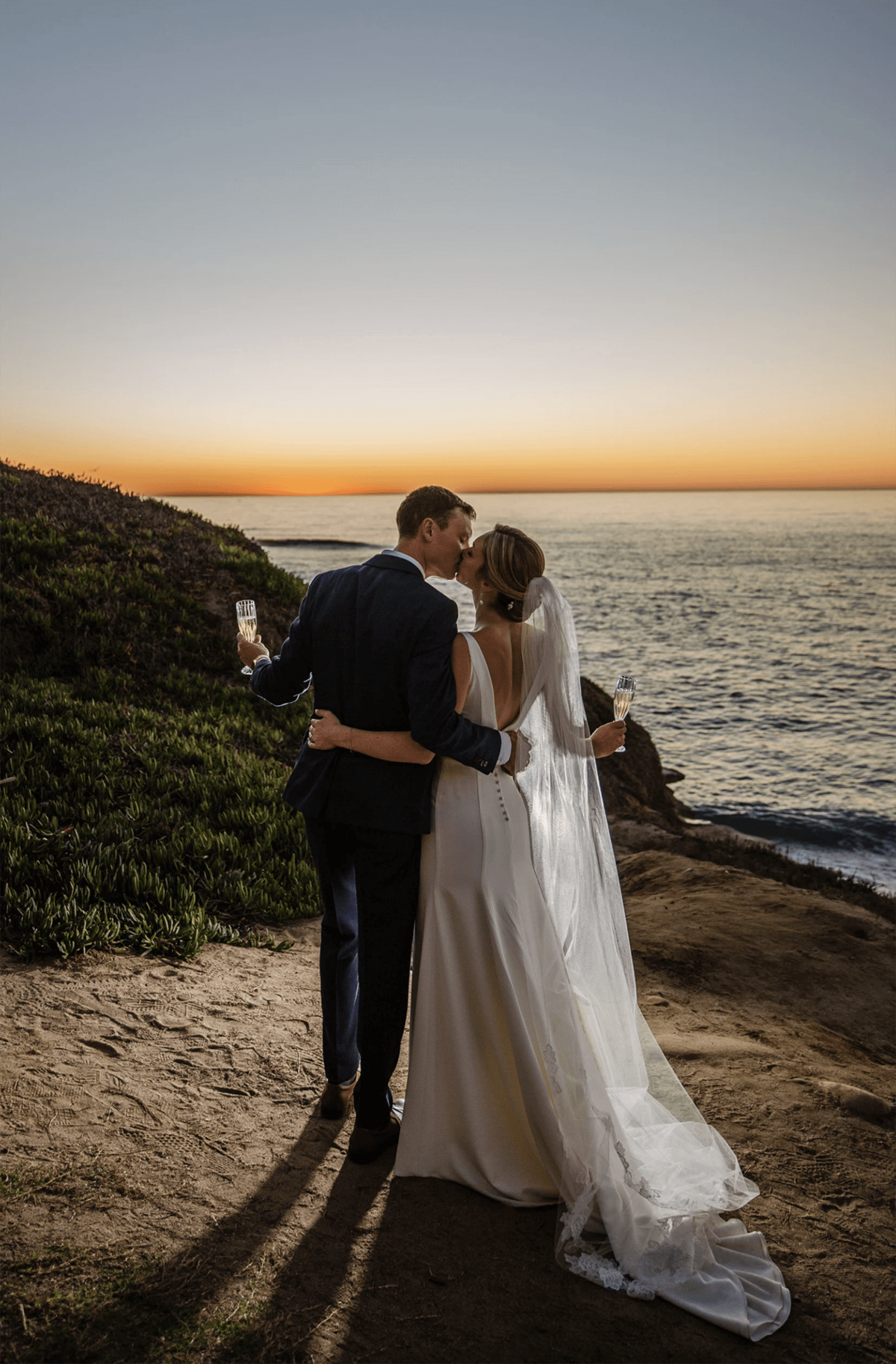 la jolla-sunset-cliffside-wedding-kiss-champagne-toast